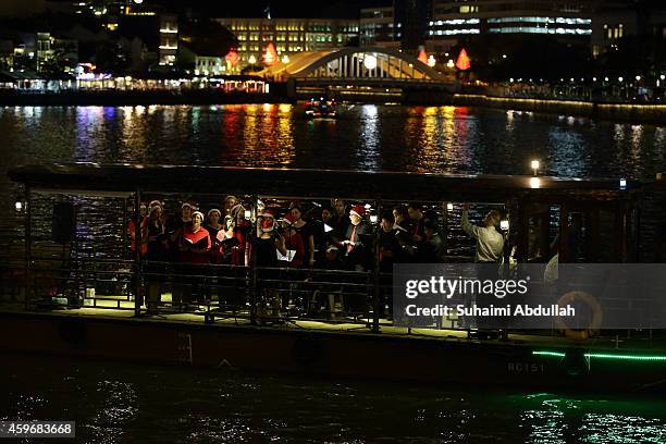Carollers perform on board the river boat during the Christmas by the River event at Boat Quay on November 28, 2014 in Singapore. The annual light-up...