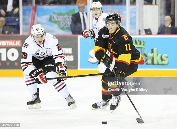 Michael Cramarossa of the Belleville Bulls gets past Aleksandar Mikulovich of the Niagara IceDogs during an OHL game between the Belleville Bulls and...