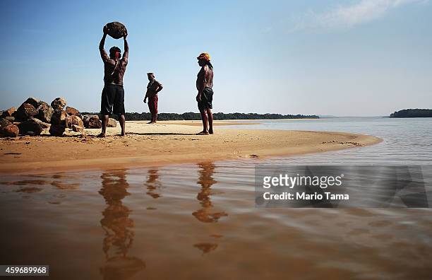 Member of the Munduruku indigenous tribe breaks rocks on the banks of the Tapajos River in preparation for a protest against plans to construct a...