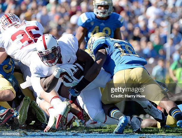 Remound Wright of the Stanford Cardinal runs in for a touchdown as he is hit by Fabian Moreau of the UCLA Bruins during the first quarter at Rose...