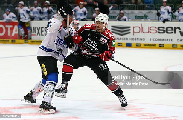 Charles Stephens of Koeln and Nicholas Petersen of Schwenningen battle for the puck during the DEL match between Koelner Haie and Schwenninger Wild...