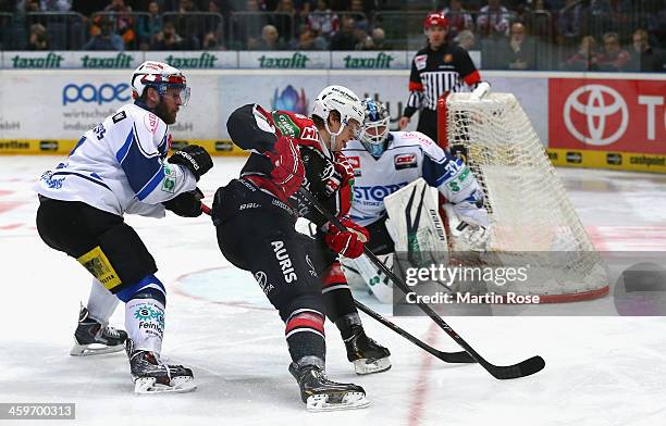 Andreas Falk of Koeln and Nicholas Johnson of Schwenningen battle for the puck during the DEL match between Koelner Haie and Schwenninger Wild Wings...