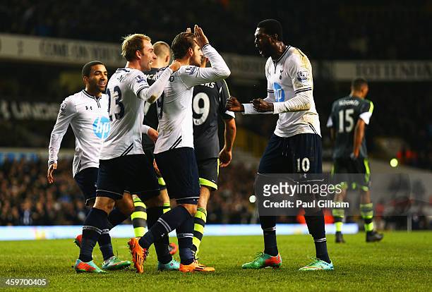 Roberto Soldado of Tottenham Hotspur is congratulated by team mates including Emmanuel Adebayor and Christian Eriksen after scoring from the penalty...
