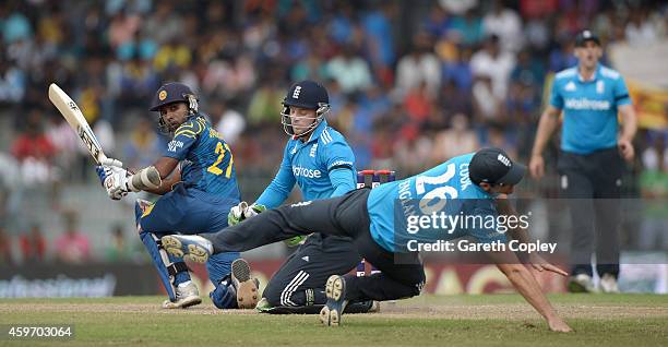 Mahela Jayawardena of Sri Lanka hits past Jos Buttler and England captain Alastair Cook during the 2nd One Day International match between Sri Lanka...