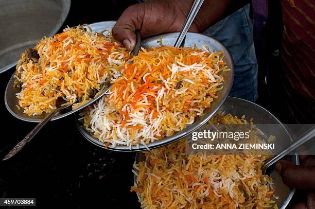 Plates of mutton biryani are served at an outside eatery in Lucknow on November 22, 2014. Biryani is a South Asian dish made with rice, spices and...