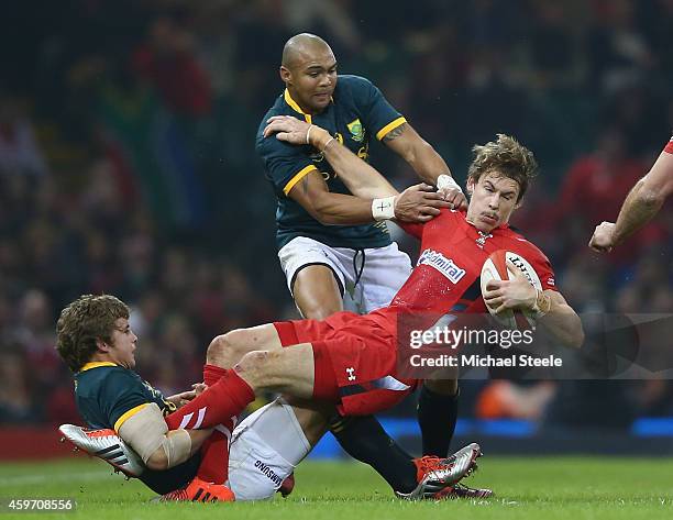 Liam Williams of Wales holds onto the ball as Pat Lambie and Cornal Hendricks of South Africa challenge during the International match betwwen Wales...