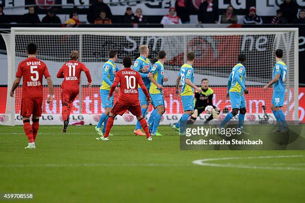 Hakan Calhanoglu of Leverkusen fires in a free kick towards the Koeln wall as goalkeeper Timo Horn of Koeln tries to save and Karim Bellarabi scores...