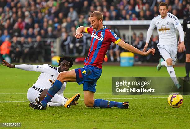 Wilfried Bony of Swansea City shoots past Brede Hangeland of Crystal Palace to score their first goal during the Barclays Premier League match...