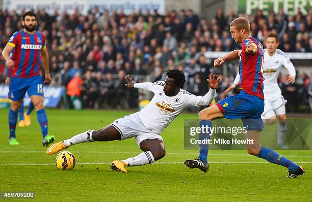 Wilfried Bony of Swansea City shoots past Brede Hangeland of Crystal Palace to score their first goal during the Barclays Premier League match...