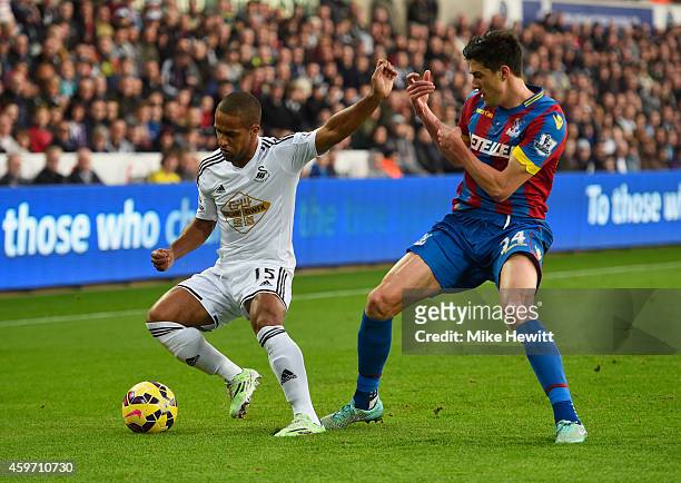 Wayne Routledge of Swansea City holds off Martin Kelly of Crystal Palace during the Barclays Premier League match between Swansea City and Crystal...