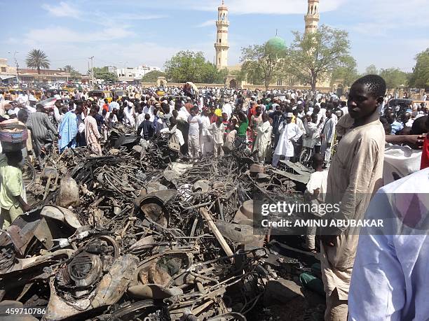 Residents look at a burnt motorcycles outside the central mosque in northern Nigeria's largest city of Kano on Novemer 29 a day after twin suicide...