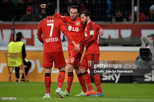 Josip Drmic of Leverkusen celebrates with team mates Heung Min Son and Gonzalo Castro after scoring his team's third goal during the Bundesliga match...