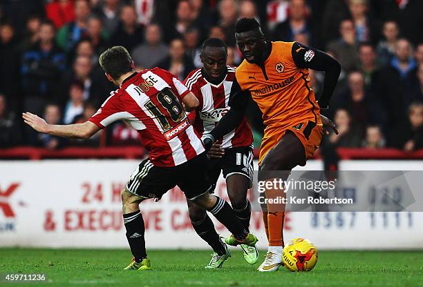 Bakary Sako of Wolverhampton Wanderers holds off the challenge of Alan Judge and Moses Odubajo of Brentford during the Sky Bet Championship match...