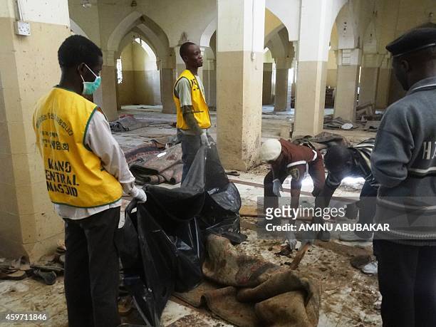 Volunteers remove blood-stained carpets from the central mosque in northern Nigeria's largest city of Kano on November 29 a day after twin suicide...