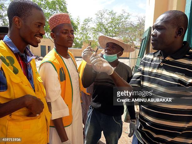 Volunteers examine spent bullets outside the central mosque in northern Nigeria's largest city of Kano on November 29 a day after twin suicide blasts...