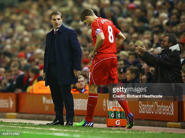 Fan applauds as Steven Gerrard of Liverpool prepares to come onto the pitch as a substitute alongside Brendan Rodgers manager of Liverpool during the...