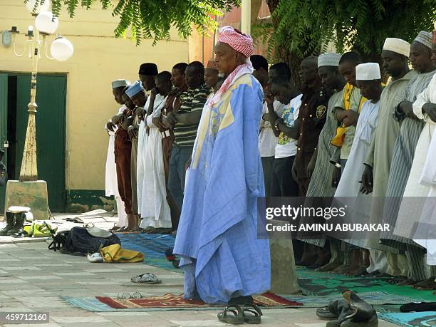 Muslim faithful observe afternoon prayers outside the central mosque in northern Nigeria's largest city of Kano on November 29 a day after twin...