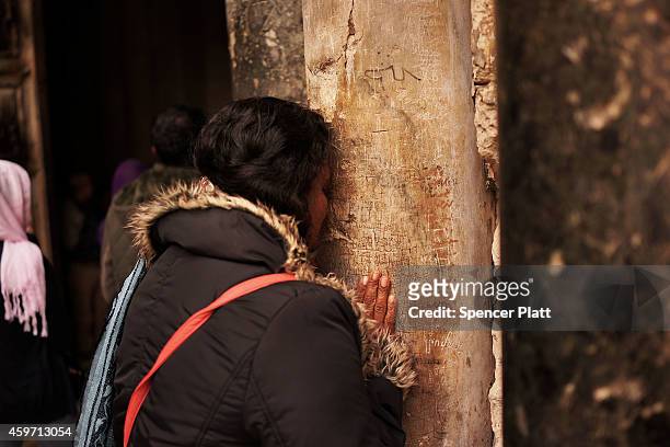 Woman kisses a pillar at the Holy Sepulchre kiss on November 29, 2014 in Jerusalem, Israel.The church is said to be where Jesus was crucified and...