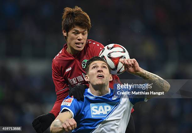Hiroki Sakai of Hannover jumps for a header with Steven Zuber of Hoffenheim during the Bundesliga match between 1899 Hoffenheim and Hannover 96 at...