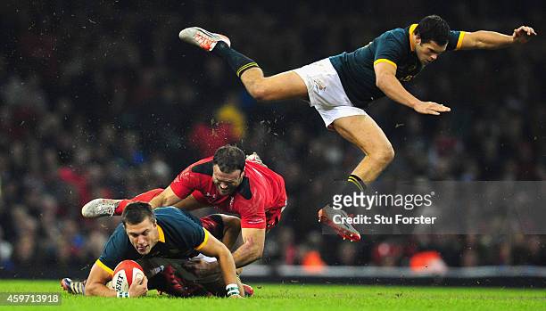 Wales centre Jamie Roberts tackles Handre Pollard as Jan Serfontein goes flying during the Autumn international match between Wales and South Africa...