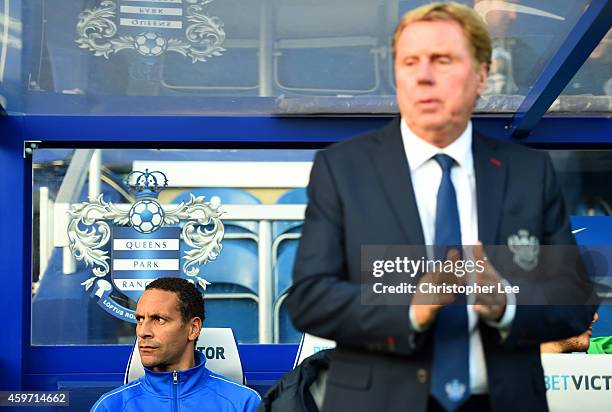 Rio Ferdinand of QPR looks on from the bench next to Harry Redknapp the QPR manager during the Barclays Premier League match between Queens Park...