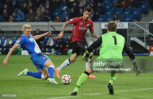 Joselu of Hannover scores his team's second goal past goalkeeper Oliver Baumann of Hoffenheim and Andreas Beck of Hoffenheim during the Bundesliga...