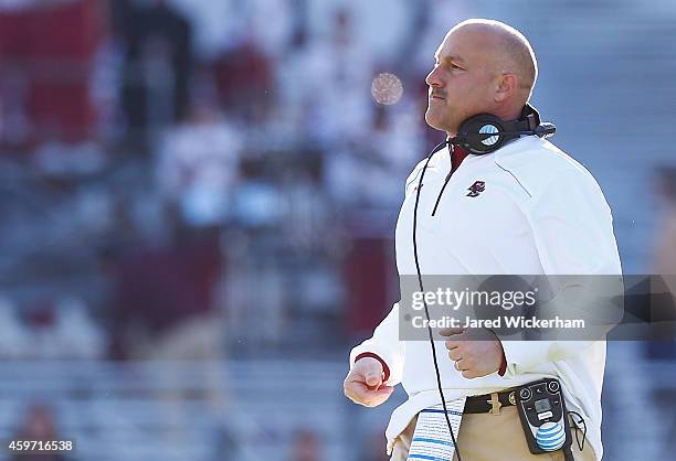 Head coach Steve Addazio of the Boston College Eagles runs after his players during a scrum in the first half against the Syracuse Orangemen during...