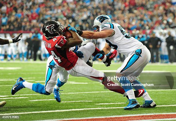 Jason Snelling of the Atlanta Falcons scores a first quarter touchdown after being hit by Luke Kuechly of the Carolina Panthers at the Georgia Dome...