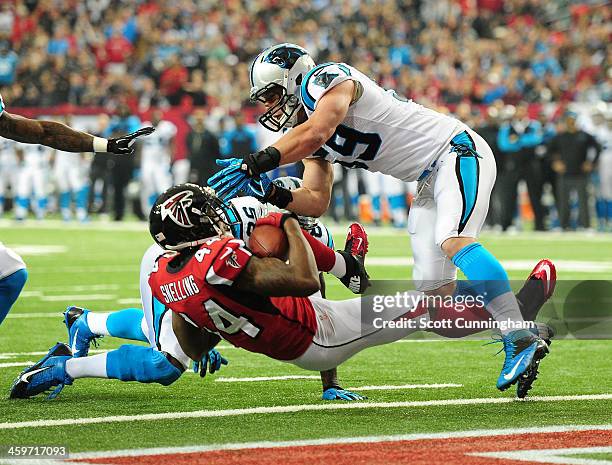 Jason Snelling of the Atlanta Falcons scores a first quarter touchdown after being hit by Luke Kuechly of the Carolina Panthers at the Georgia Dome...