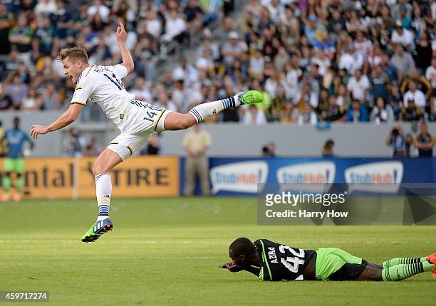 Robbie Rogers of Los Angeles Galaxy is tripped by Micheal Azira of Seattle Sounders FC during the Western Conference Final at StubHub Center on...