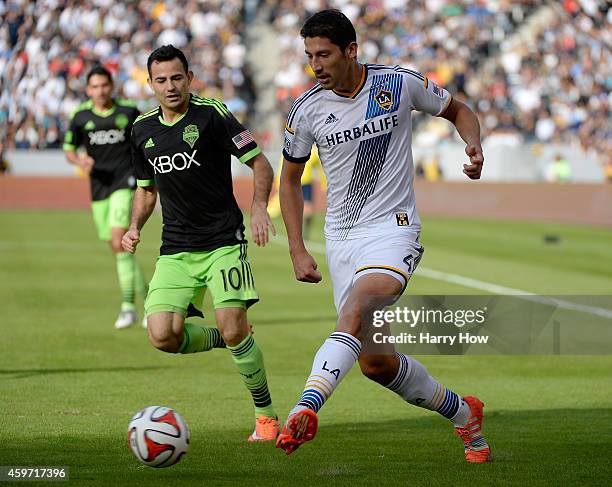 Omar Gonzalez of Los Angeles Galaxy looks to pass as he is chased by Marco Pappa of Seattle Sounders FC during the Western Conference Final at...