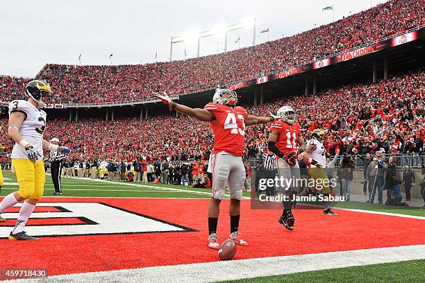Darron Lee of the Ohio State Buckeyes celebrates after returning a recovered fumble 33-yards for a touchdown in the fourth quarter against the...