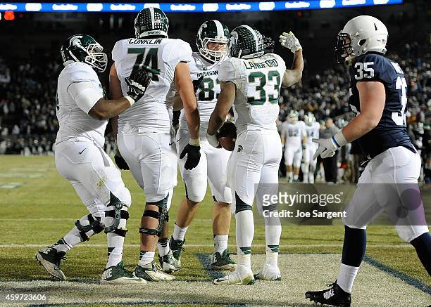 Jeremy Langford of the Michigan State Spartans celebrates his fourth quarter touchdown with teammates in front of Matthew Baney of the Penn State...