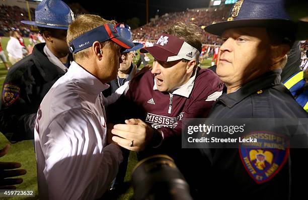 Head coach Hugh Freeze of the Mississippi Rebels shakes hands with head coach Dan Mullen of the Mississippi State Bulldogs after the Rebels defeated...