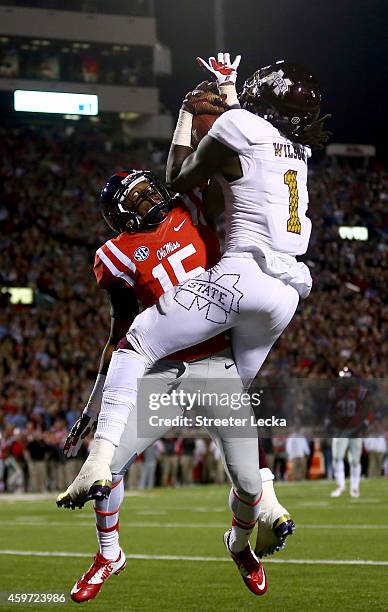 De'Runnya Wilson of the Mississippi State Bulldogs catches a touchdown over Kendarius Webster of the Mississippi Rebels during their game at...