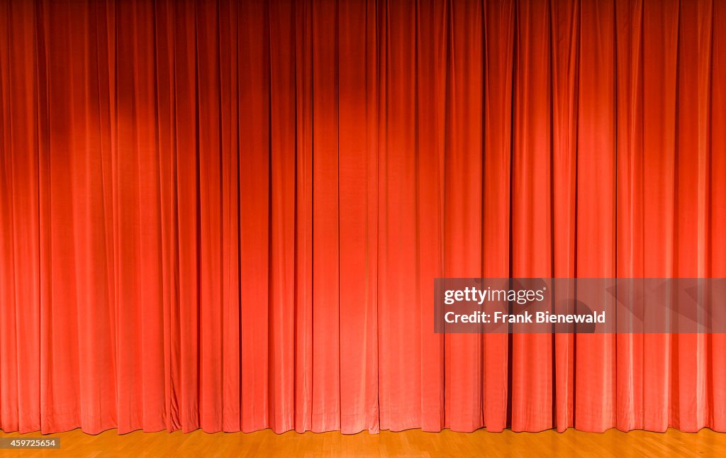 A curtain in light red color, covering a theater stage...