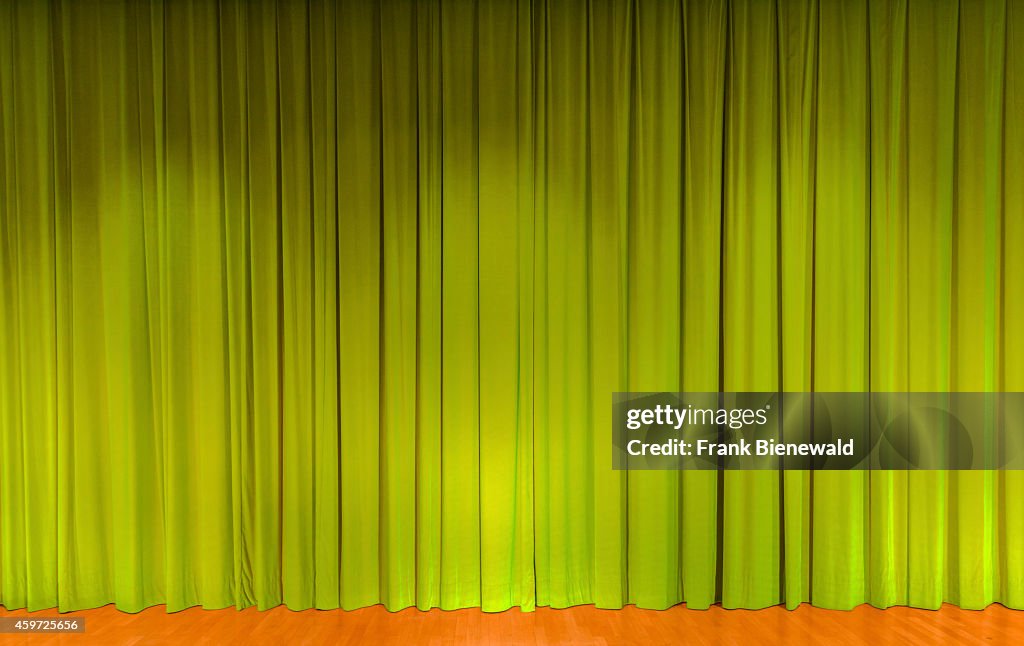 A curtain in green color, covering a theater stage...