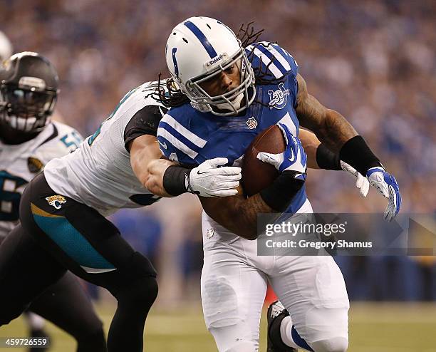 Trent Richardson of the Indianapolis Colts runs for a fist quarter touchdown through the tackle of Paul Posluszny of the Jacksonville Jaguars at...