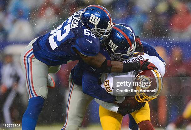 Middle linebacker Jon Beason and cornerback Prince Amukamara of the New York Giants tackle wide receiver Pierre Garcon of the Washington Redskins in...