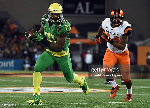Running back Royce Freeman of the Oregon Ducks runs the ball for a touchdown as linebacker Jabral Johnson of the Oregon State Beavers gives chase...