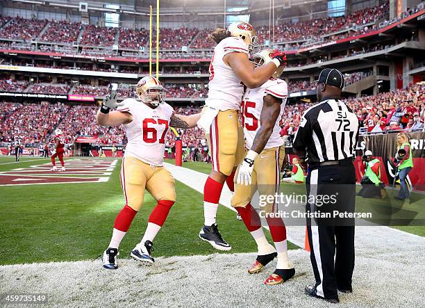 Vernon Davis of the San Francisco 49ers celebrates with his teammates after scoring a 3 yard touchdown pass from Colin Kaepernick against the Arizona...