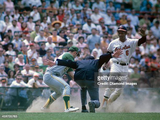 Outfielder Paul Blair of the Baltimore Orioles slides safely into thirdbase as thirdbaseman Sal Bando of the Oakland A's applies the tag too late...