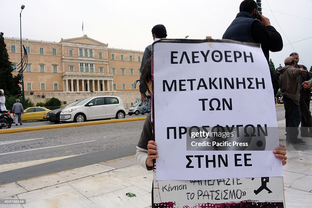 A young refugee holds a big picket in front of the Greek...
