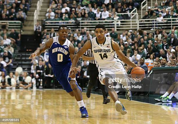 Gary Harris of the Michigan State Spartans drives the ball to the basketball as Tradarri McPhearson of the New Orleans Privateers defends during the...