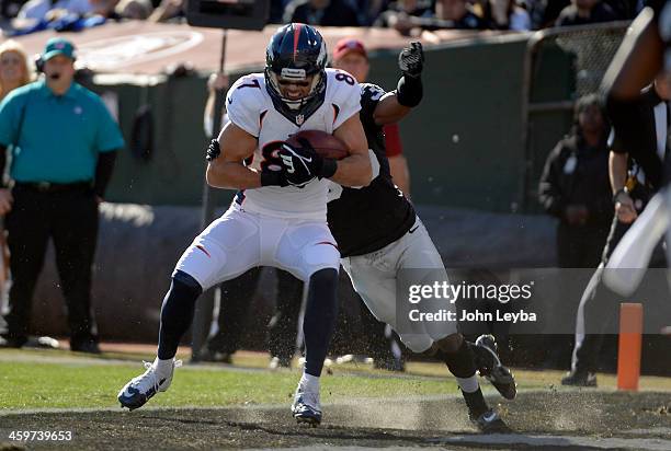 Denver Broncos wide receiver Eric Decker catches a first quarter touchdown on Oakland Raiders defensive back Chimdi Chekwa at O.co Coliseum.