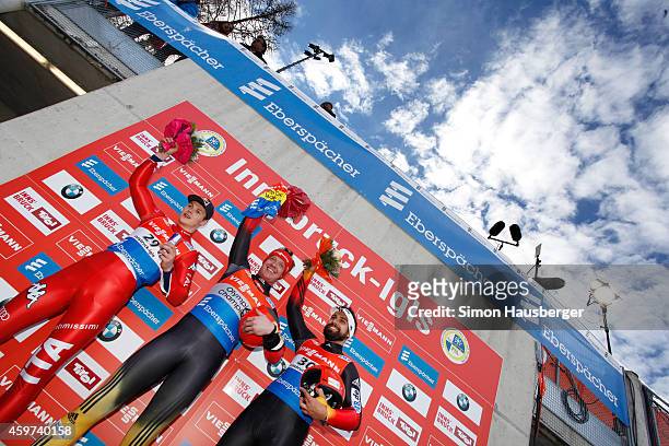 Dominik Fischnaller of Italy, Felix Loch and Andi Langenhan of Germany pose at the flower ceremony after the Viessmann Luge World Cup at...