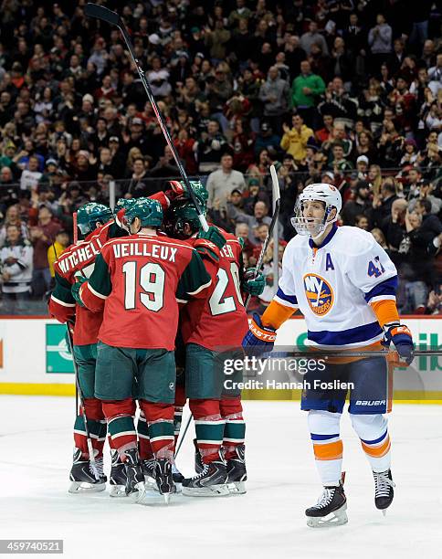 The Minnesota Wild celebrate a goal by Ryan Suter of the Minnesota Wild as Andrew MacDonald of the New York Islanders looks on during the first...