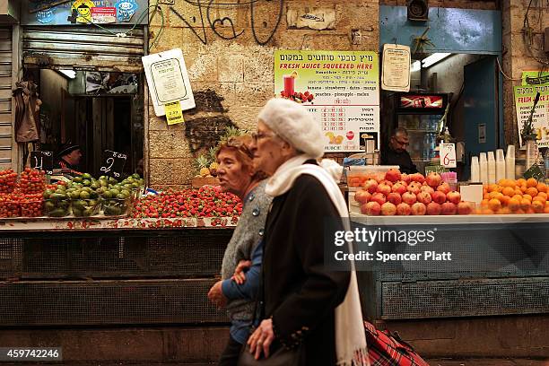 Couple walks through a market in the downtown area on November 30, 2014 in Jerusalem, Israel. Nine Israelis have been killed in a series of...