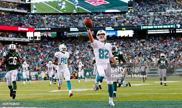 Brian Hartline of the Miami Dolphins runs in a touchdown against the New York Jets on December 1, 2013 at MetLife Stadium in East Rutherford, New...