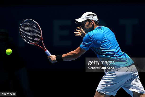 Daniel Munoz-De La Nava of Spain plays a backhand to John Isner of the United States in the men's singles match during day three of the Hopman Cup at...